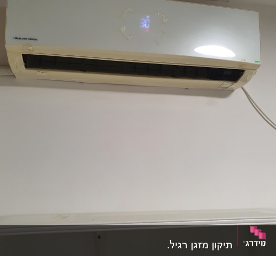 מזגן מותקן על קיר עם מדף מתחת
